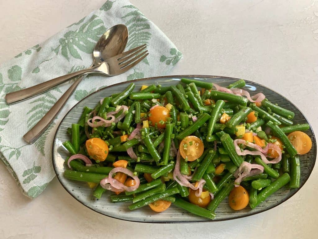 A platter of green bean salad with pickled red onions and jalapeno mustard dressing