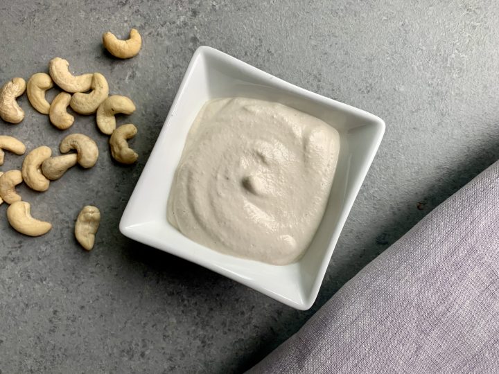 All-purpose cashew cream in serving bowl displayed with cashews next to it.