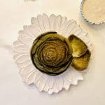 Steamed Artichoke with Dipping Sauce on a white flower plate