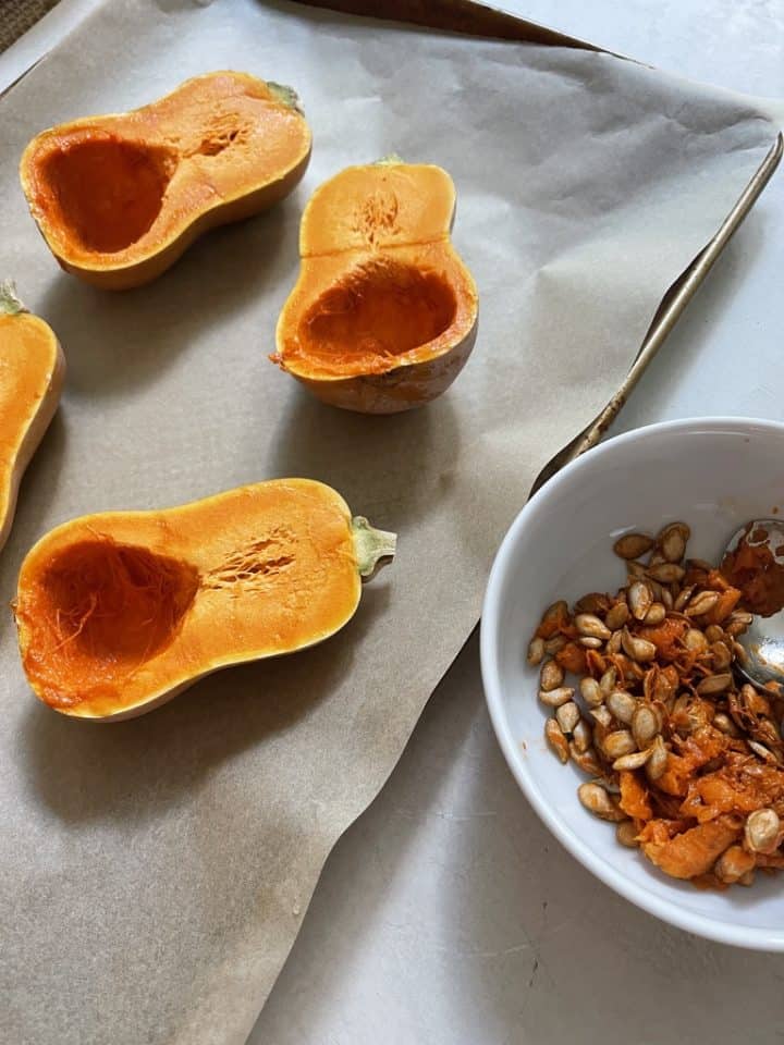 Honeynut Squash cut open and seeds scooped out in a bowl