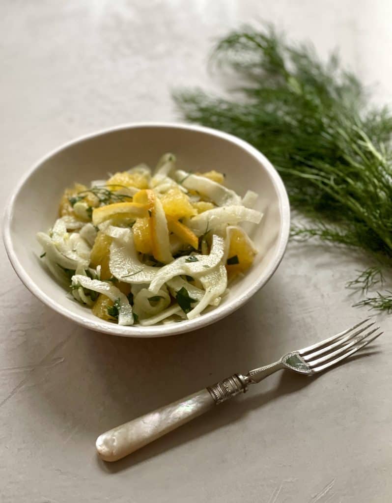 Shaved Fennel Citrus Salad with fork and fresh fennel on a tabletop